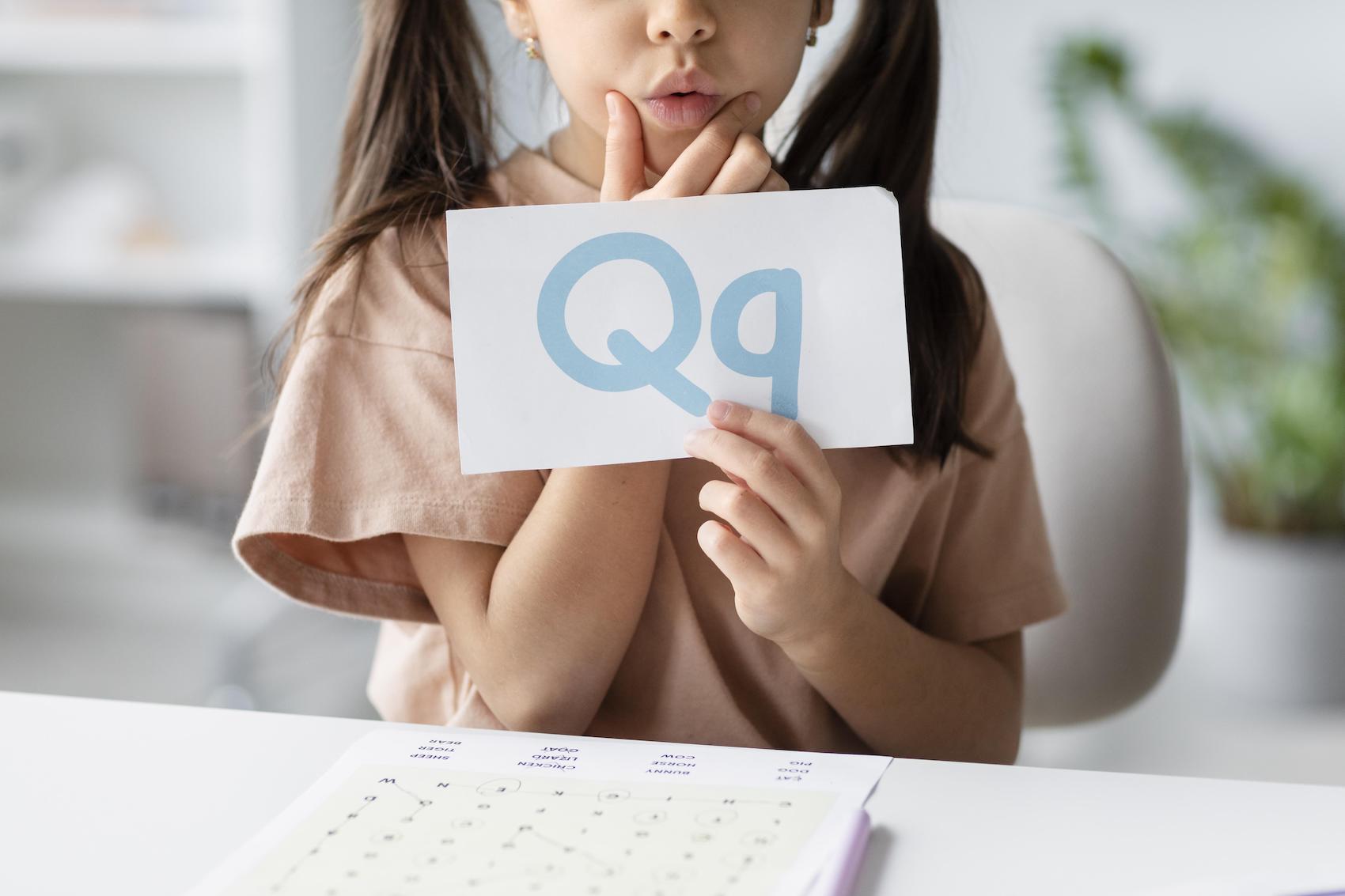 little-girl-holding-paper-with-letter-it-speech-therapy